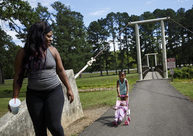 Destiny Johnson and her daughter Maliyah walk through Swinging Bridge Park on Tuesday, Aug. 9, 2016, in Dayton, Tenn. The city was awarded a $348,477 grant from TDOT to fund phase 2 of a greenway system that would connect Point Park to downtown Dayton along Richland Creek.