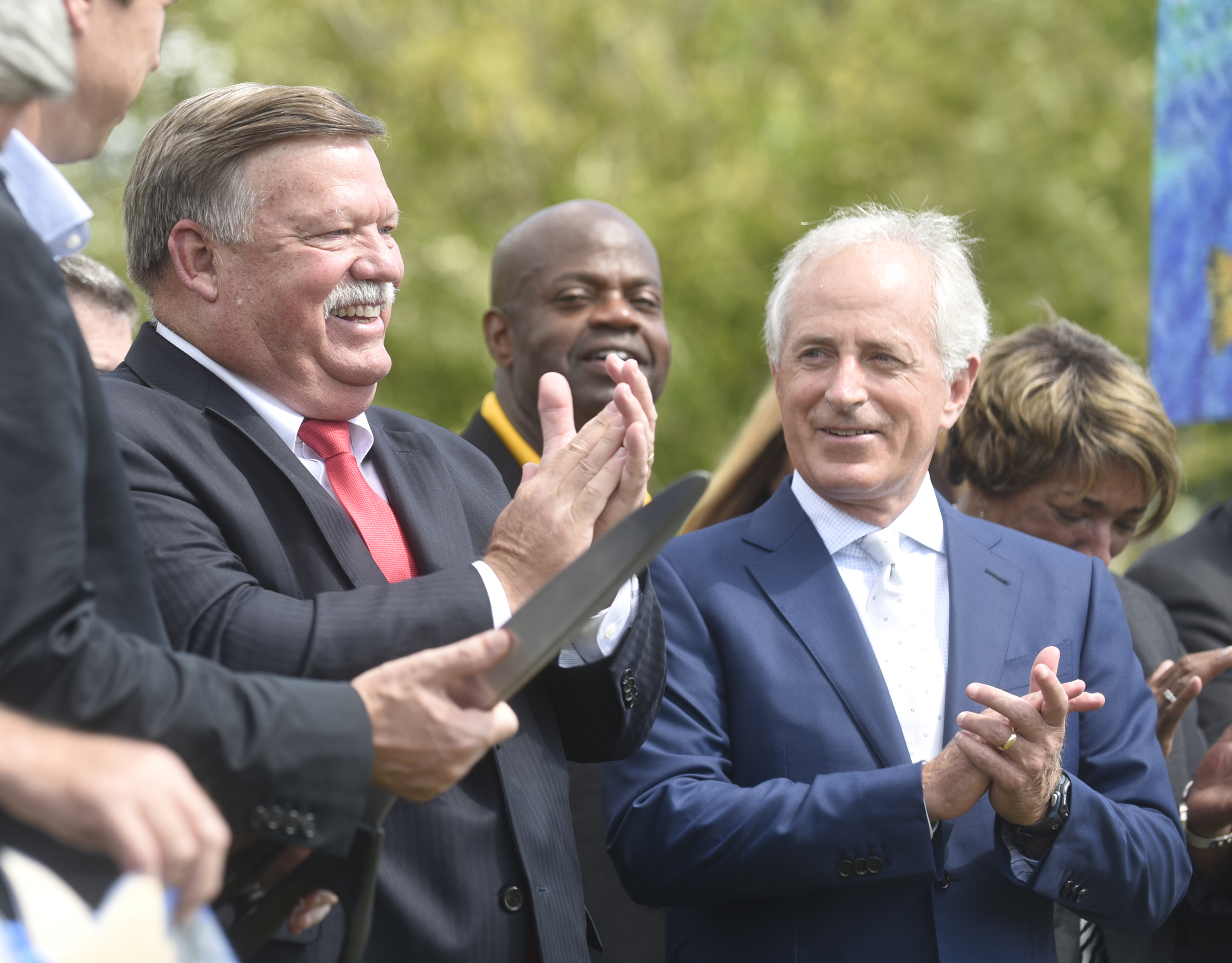 County Mayor Jim Coppinger, County Commissioner Warren Mackey and Sen. Bob Corker, from left, celebrate after cutting the ribbon during the grand opening of the 3-mile extension of the Riverwalk Friday, August 12, 2016.