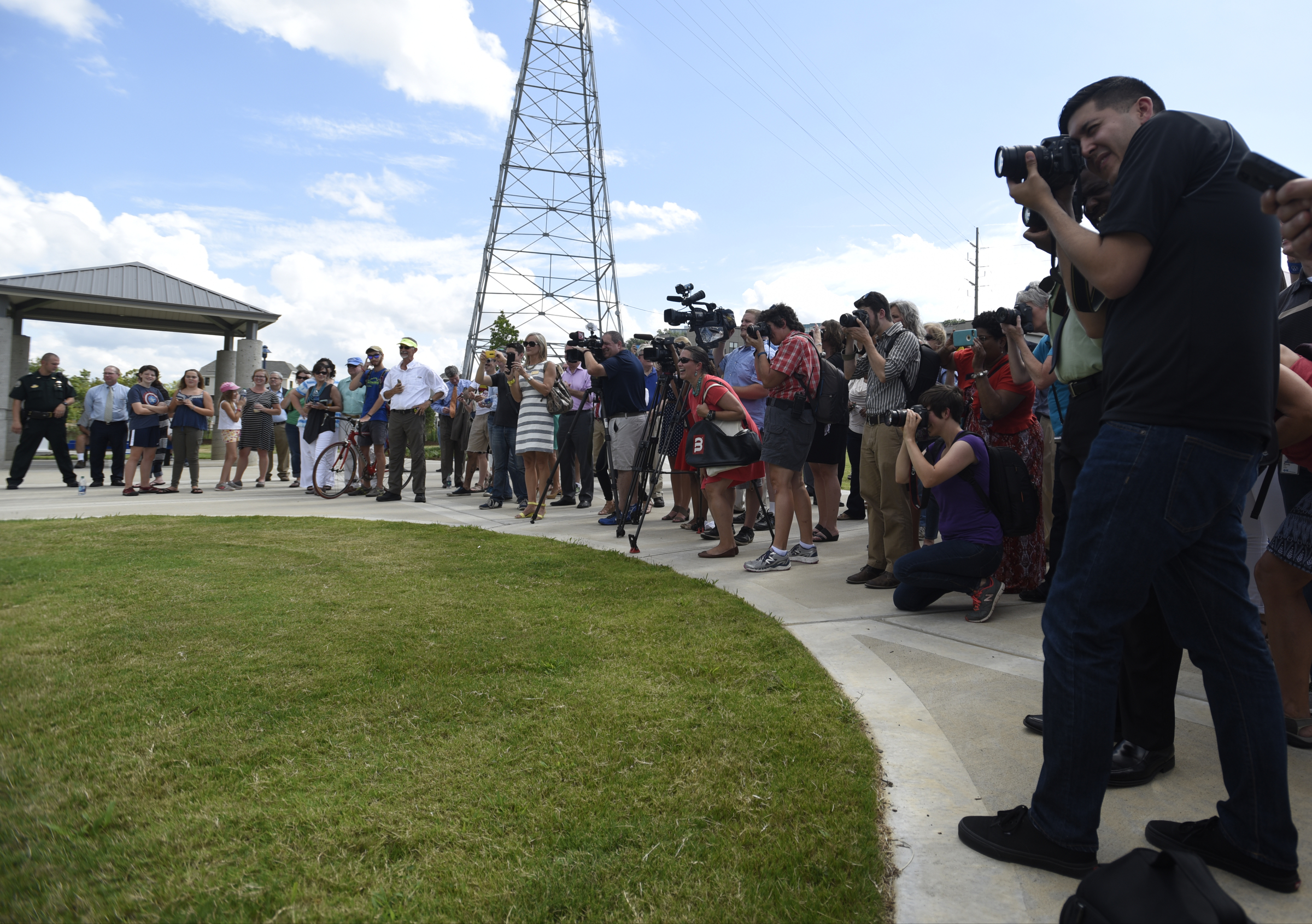 A crowd gathers to watch and photograph the ribbon cutting of the 3-mile extension of the Riverwalk Friday, August 12, 2016.