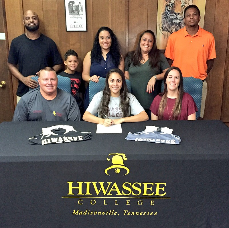 Walker Valley High School graduate Kat Alomar, seated center, is joined by family members and coaches as she signs paperwork to continue her basketball career at Hiwassee College.