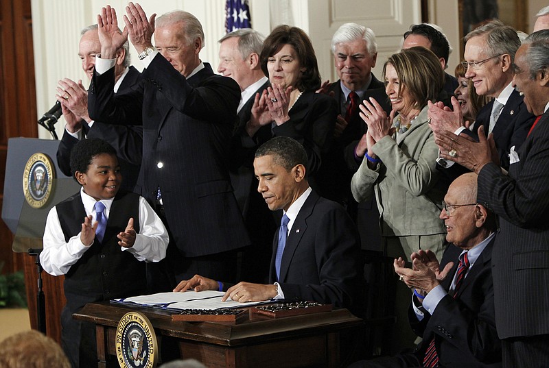 In this March 23, 2010, file photo President Barack Obama is applauded after signing the Affordable Care Act into law in the East Room of the White House in Washington.