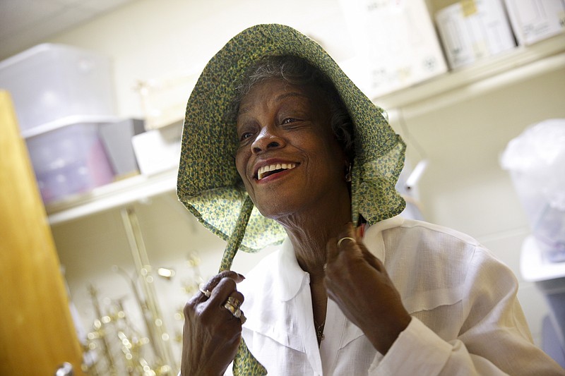 Atheria Freeman dons a bonnet for her 19th century costume before a rehearsal for a celebration of Second Missionary Baptist Church's 150th anniversary on Friday, Aug. 12, 2016, in Chattanooga, Tenn. The church celebrates its anniversary Sunday.