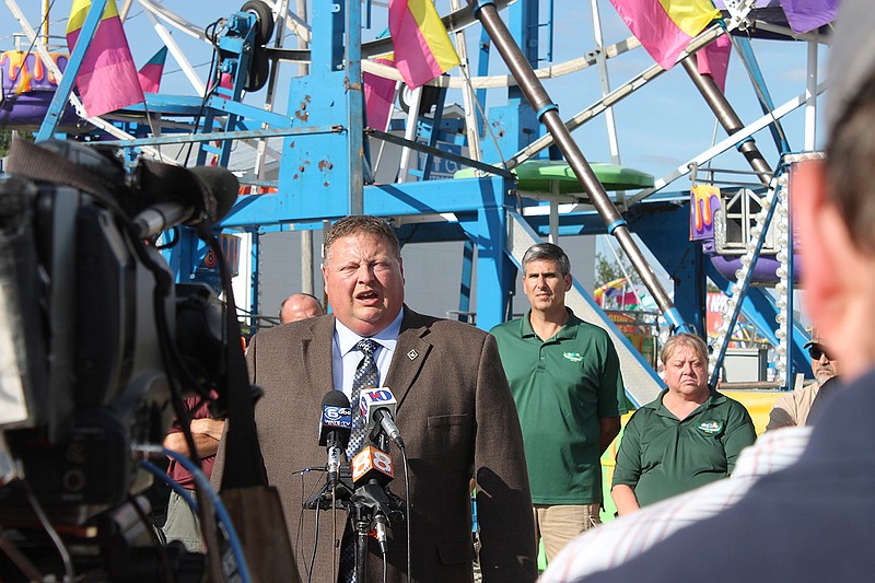 Greeneville Police Detective Capt. Tim Davis answers questions at the foot of the Ferris wheel at the Greene County Fair Tuesday, Aug. 9, 2016, during a news conference. Members of the Greene County Fair Board of Directors stand behind him. Government investigators are still sorting out how a Ferris wheel seat flipped over at the county fair, sending three children plummeting 30 to 45 feet to the ground.