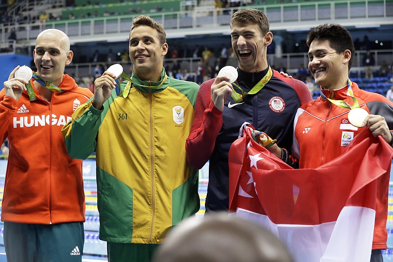 Silver medal winners Hungary's Laszlo Cseh, South Africa's Chad Le Clos and United States' Michael Phelps and Singapore's gold medal winner Joseph Schooling, from left, celebrate in the men's 100-meter butterfly medals ceremony during the swimming competitions at the 2016 Summer Olympics, Friday, Aug. 12, 2016, in Rio de Janeiro, Brazil. 