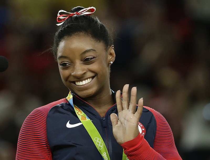 United States' Simone Biles celebrates on the podium after winning vault gold during the artistic gymnastics women's apparatus final at the 2016 Summer Olympics in Rio de Janeiro, Brazil, Sunday, Aug. 14, 2016.