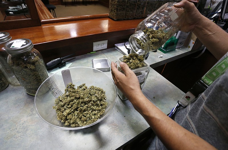 An employee places marijuana for sale into glass containers at The Station, a retail and medical cannabis dispensary, in Boulder, Colo., Thursday, Aug. 11, 2016. The DEA announced Thursday, Aug. 11, 2016, that the Obama administration will keep marijuana on the list of the most dangerous drugs, despite growing popular support for legalization, but will allow more research into its possible medical benefits.