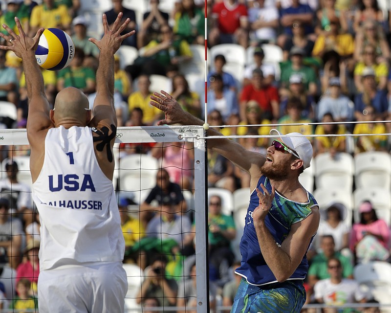 
              Brazil's Alison Cerutti, right, hits over United States' Phil Dalhausser during a men's beach volleyball quarterfinal match at the 2016 Summer Olympics in Rio de Janeiro, Brazil, Monday, Aug. 15, 2016. (AP Photo/Marcio Jose Sanchez)
            