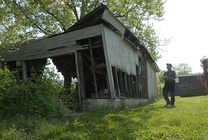 Rossville City Code Enforcement Officer Mark Harris, right, takes another look at an unsightly building in the 100 block of Cherry Street in 2010. The code enforcement and building issues that Rossville has faced are what Catoosa County's Building and Zoning departments are concerned with in their own county.