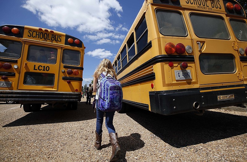 A student prepares to board a bus to go home from school (AP File Photo/Rogelio V. Solis, File)