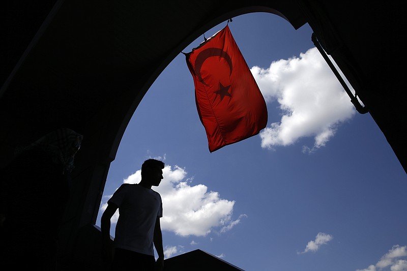 
              A pedestrian passes under a Turkish flag in Istanbul, Sunday, Aug. 14, 2016. Turkish authorities have prepared an official request for the temporary arrest of United States-based Islamic cleric Fethullah Gulen over his alleged involvement in the coup attempt on July 15, Turkey's state-run Anadolu news agency said Saturday. (AP Photo/Thanassis Stavrakis)
            
