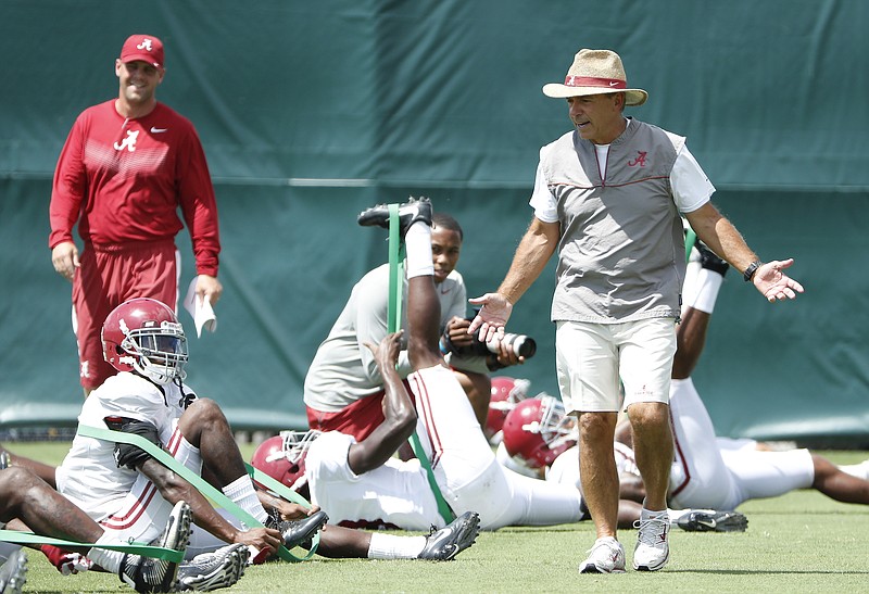 Alabama football coach Nick Saban speaks to players as they stretch before Tuesday's practice in Tuscaloosa.