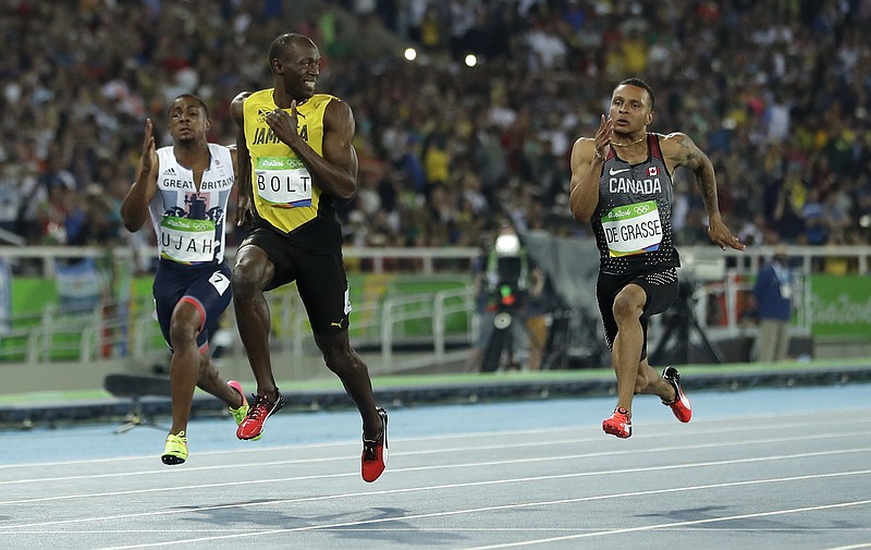 
              Jamaica's Usain Bolt looks to Canada's Andre De Grasse, right, during a men's 100-meter semifinal during the athletics competitions in the Olympic stadium of the 2016 Summer Olympics in Rio de Janeiro, Brazil, Sunday, Aug. 14, 2016. (AP Photo/Matt Slocum)
            