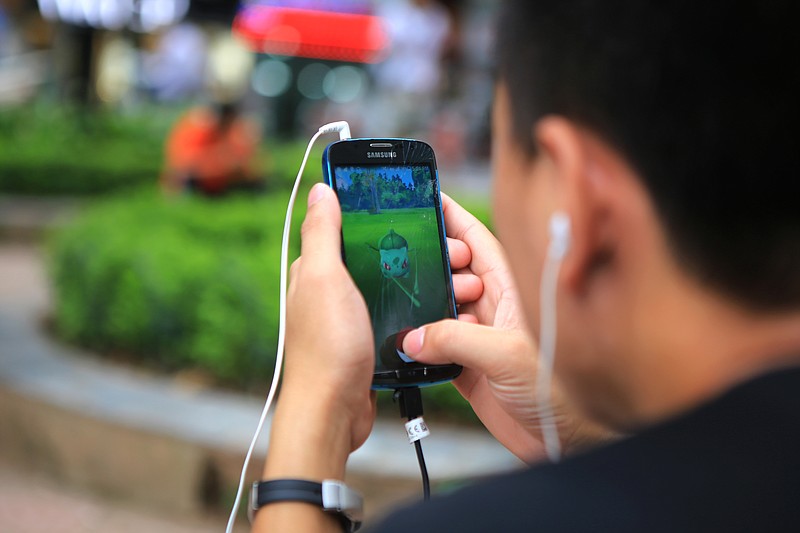 
              A man plays "Pokemon Go" at a popular PokeStop in Hanoi, Vietnam on Saturday 13 August 2016. One week after being released in Vietnam, the game has become one of the most talked-about topics in the Southeast Asian country. (AP Photo/Hau Dinh)
            