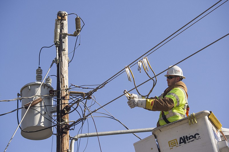 A Georgia Power crewman goes through the process of restoring power to a neighborhood as he works on a line in Riverdale, Ga.