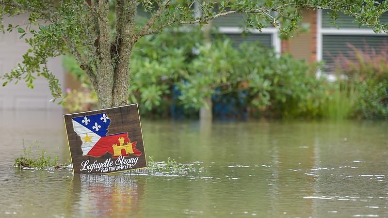 Floodwaters rise as the Vermillion River spills over the levee along River Road last week in Lafayette, La. (Scott Clause/The Daily Advertiser via AP)