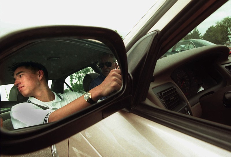 KRT NEWS STORY SLUGGED: TEENDRIVING KRT PHOTOGRAPH BY  RICHARD KOCI HERNANDEZ/SAN JOSE MERCURY NEWS (KRTW2-June 9) Tyler Ichien, 15, of Los Gatos, California, looks over his shoulder before backing out of the Leigh High School Parking lot to resume his drivers education course with teacher Frank Hendricks. State driving records indicate many teenagers throughout California are scrambling to get their driver's licenses before July 1, 1998, when new state restrictions on teen drivers take effect. (SJ) AP PL KD ARR (jak22300) 1998 (COLOR)  This photo may be of interest to At-Risk Readers.