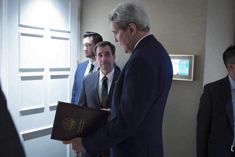 FILE - In this Oct. 23, 2015 file-pool photo, Secretary of State John Kerry, speaks to senior adviser John Kirby before a news conference in Vienna. The State Department says a $400 million cash payment to Iran was contingent on the release of American prisoners. Spokesman Kirby says negotiations over the U.S. returning Iranian money from a decades-old account was conducted separately from the prisoner talks. But he says the U.S. withheld delivery of the cash as leverage until the U.S. citizens had left Iran. (Carlo Allegri/Pool Photo via AP, File)