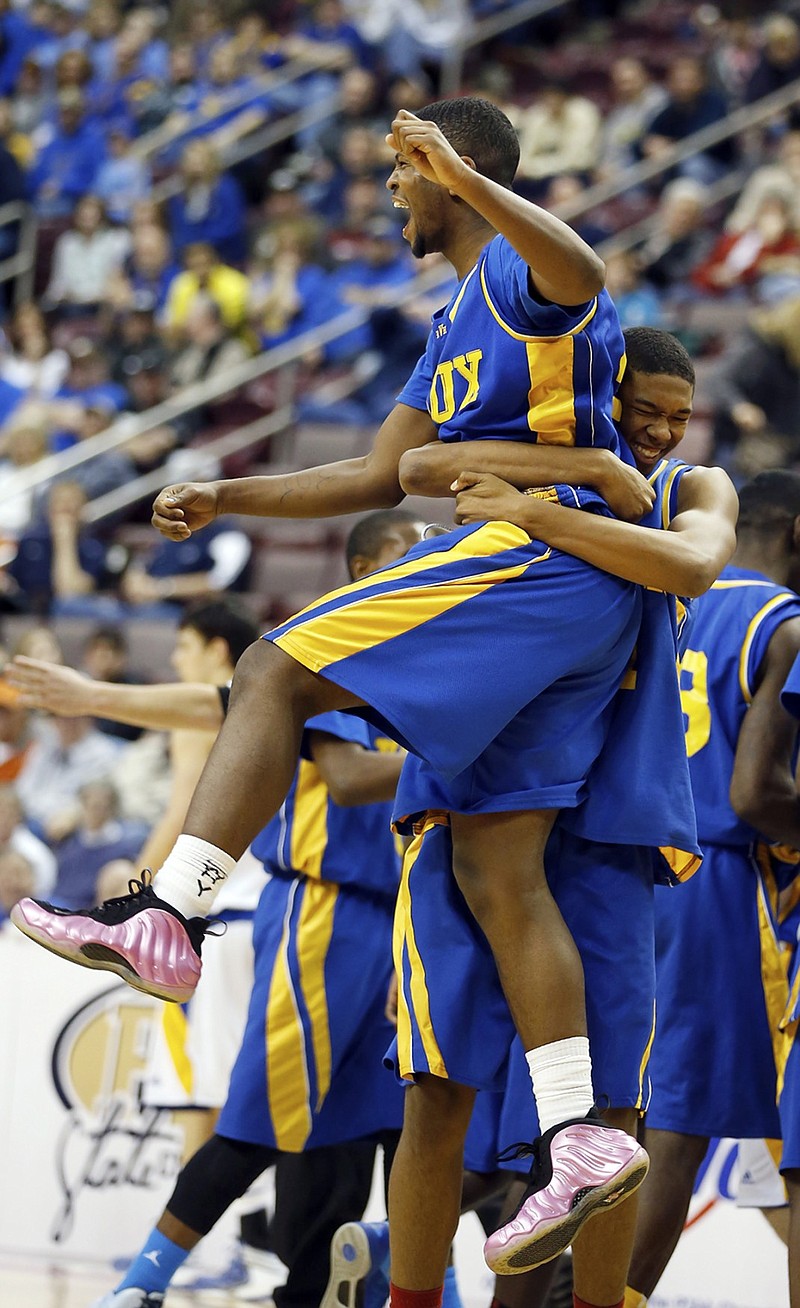 Vaux's Trayvond Massenburg, right, hugs teammate Amir Butler during Vaux's win against Johnsonburg in the Pennsylvania Interscholastic Athletic Association Class A championship game in March 2013. Massenburg, who has since played two seasons of college basketball, recently signed with UTC.