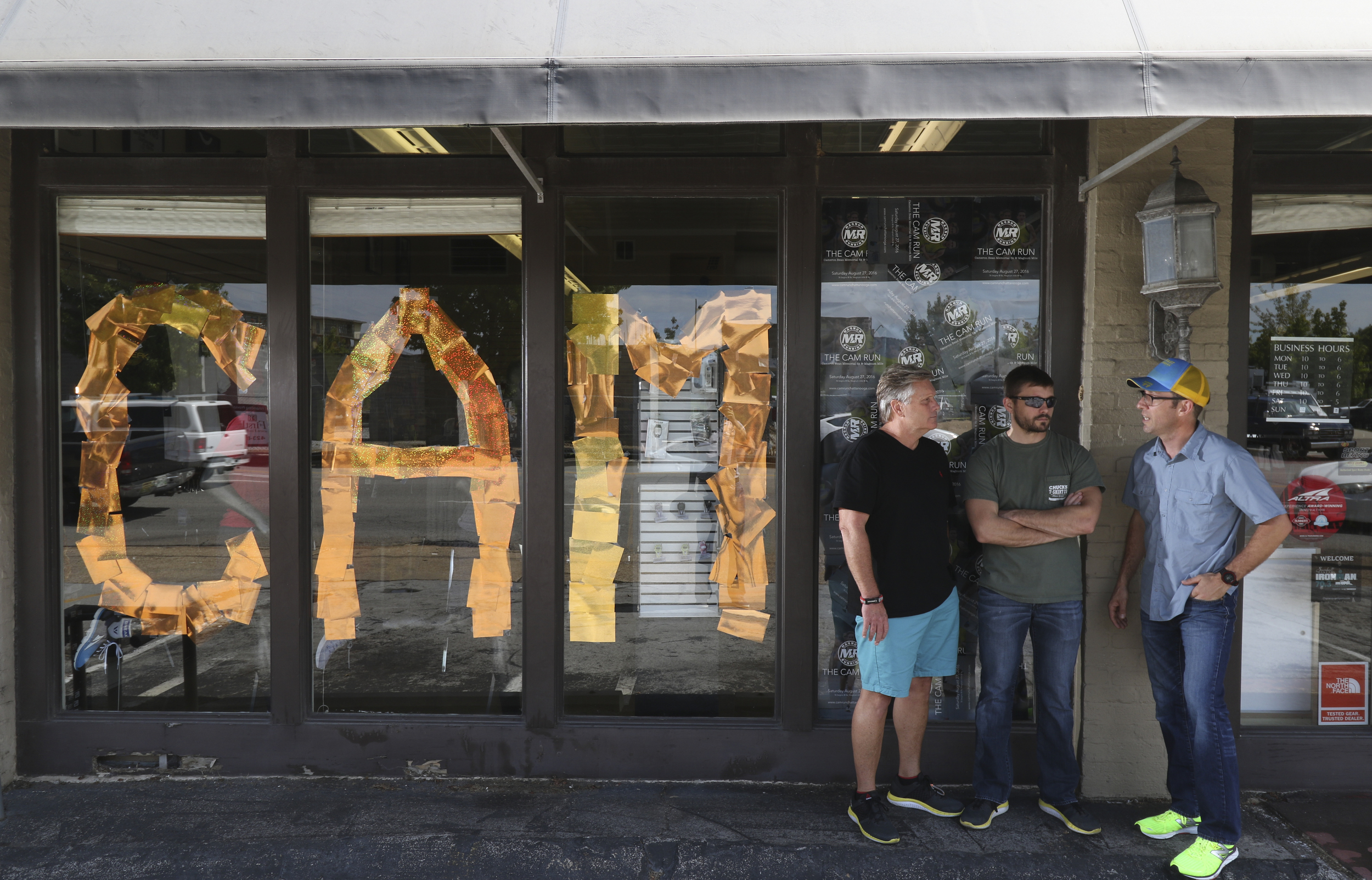 Staff Photo by Dan Henry / The Chattanooga Times Free Press- 8/18/16. Steve Bean, left, and his son Chris Bean speak to Alan Outlaw in front of Fast Break Athletics on Thursday, August 18, 2016 about next weekend's Cam Run honoring the late Cameron Bean.