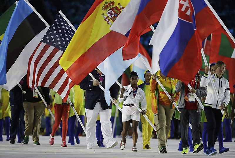 Simone Biles carries the flag of the United States during the closing ceremony Sunday night at the Olympics in Rio de Janeiro.