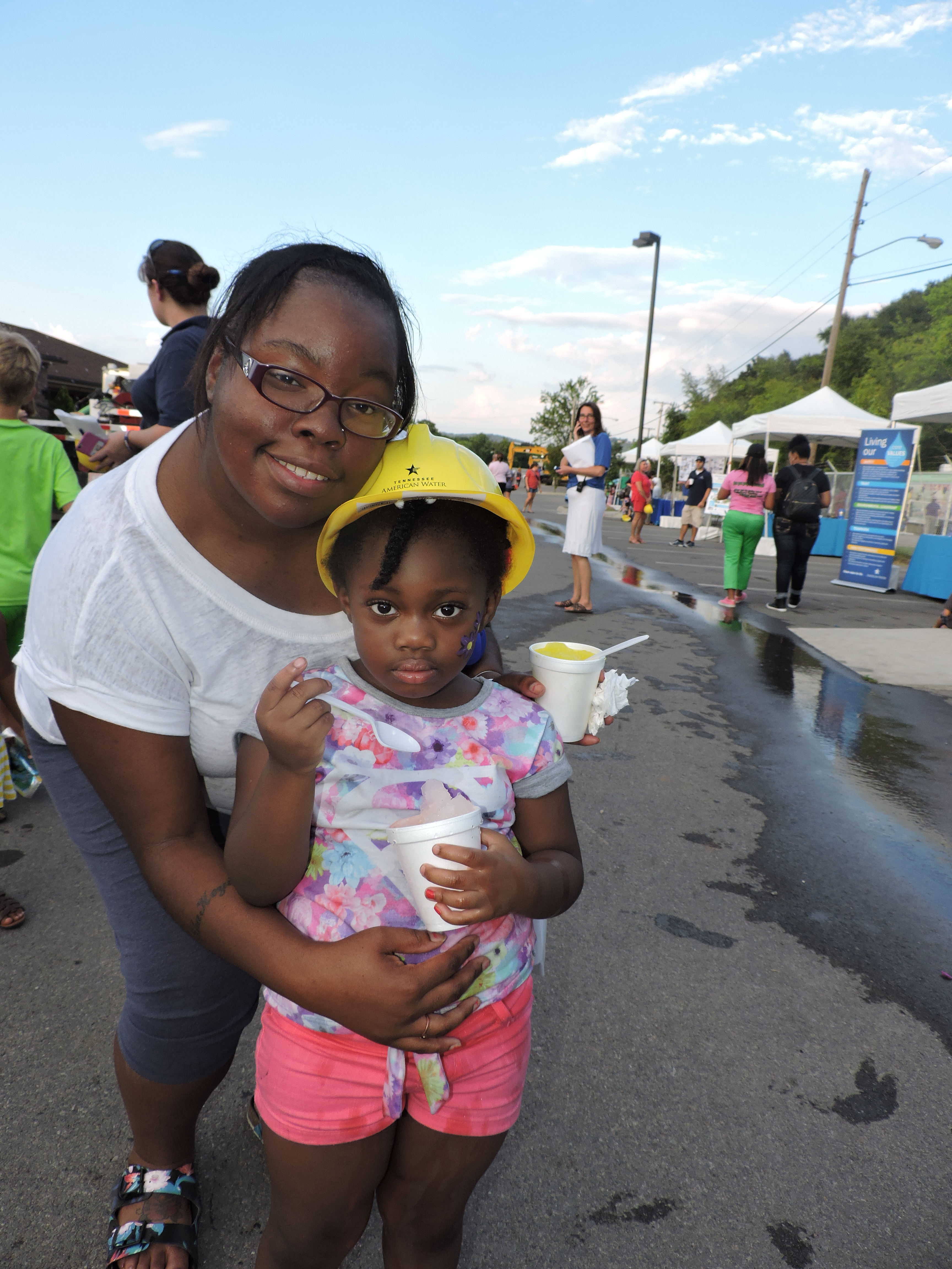 East Chattanooga residents Shakeyia Long, left, and her daughter, Zamiyah Rogers, 3, take part in the day's activities. They toured the plant, hopped aboard the Discovery Bus where they made snow and painted a couple of pictures, and Zamiyah got her face painted.