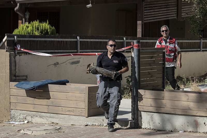 
              An Israeli police sapper carries part of a rocket which landed in a yard of a house in the city of Sderot, southern Israel, Sunday, Aug. 21, 2016. Palestinian militants in the Gaza Strip fired a rocket into southern Israel on Sunday, prompting the Israeli military to respond with airstrikes and tank fire on targets inside Gaza. No injuries were reported on either side. (AP Photo/Tsafrir Abayov)
            