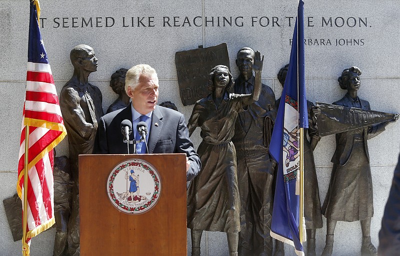 
              The statue of Barbara Johns with her hand outstretched, stands behind Virginia Gov. Terry McAuliffe as he speaks during a ceremony dealing with the restoration of rights at the Virginia Civil Rights memorial at the State Capitol in Richmond, Va., on Monday, Aug. 22, 2016. McAuliffe announced that he again restored the voting rights of about 13,000 felons who served their time after his previous attempt was thwarted by Republican lawmakers and the state Supreme Court. (Bob Brown/Richmond Times-Dispatch via AP)
            