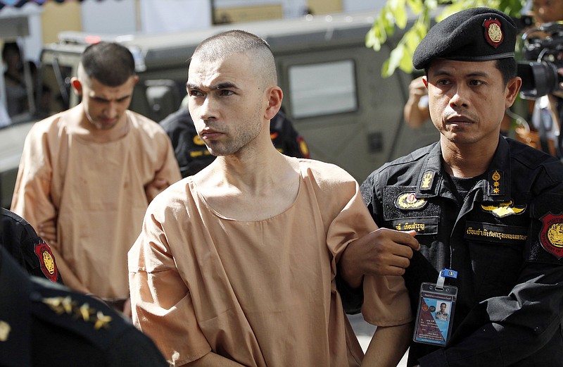 
              FILE - In this Nov. 24, 2015 file photo, police officers escort suspects in the Aug. 17 blast at Erawan Shrine, Bilal Mohammad, front, and Mieraili Yusufu, rear, as they arrive at a military court in Bangkok, Thailand. A Thai military court on Tuesday, Aug. 23, 2016 began the trial of two foreigners charged with the bombing of a popular shrine in Bangkok's center a year ago that killed 20 people and injured more than 120. (AP Photo/Sakchai Lalit, File)
            