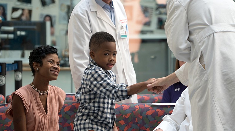 
              Zion Harvey, center, who received a double hand transplant in July 2015, shakes hands with a health care worker as his mother Pattie Ray, left, smiles during a news conference, Tuesday, Aug. 23, 2016 at The Children's Hospital of Philadelphia in Philadelphia. Zion Harvey talked about his progress since receiving a double hand transplant in July 2015, becoming the youngest hand transplant patient in the U.S., and now the boy from the Baltimore suburb of Owings Mills, Md., can throw a ball, zip his clothes and write in his journal. (AP Photo/Dake Kang)
            