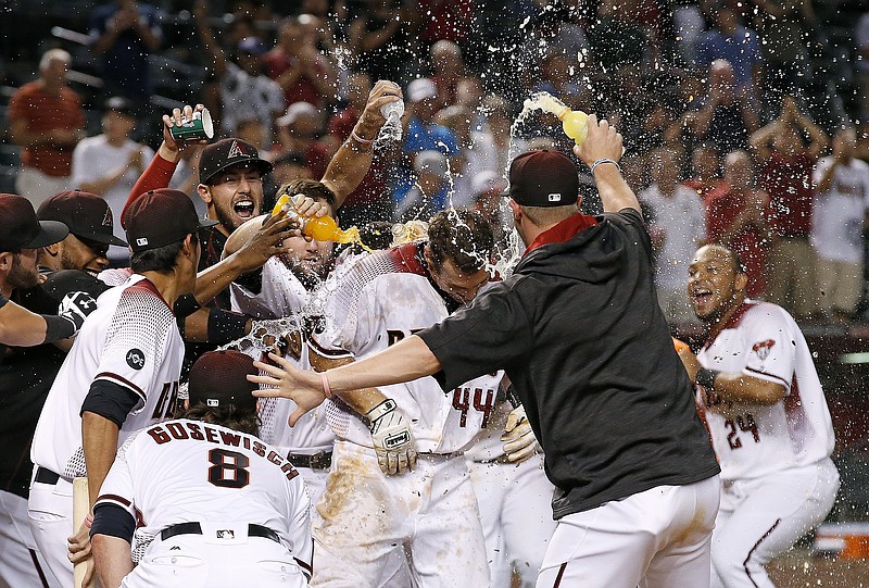 After hitting a walk off home run, Arizona Diamondbacks' Paul Goldschmidt (44) is met at home plate by teammates, including Tuffy Gosewisch (8) and Yasmany Tomas (24), during the ninth inning of a baseball game against the Atlanta Braves Monday, Aug. 22, 2016, in Phoenix. The Diamondbacks defeated the Braves 9-8.