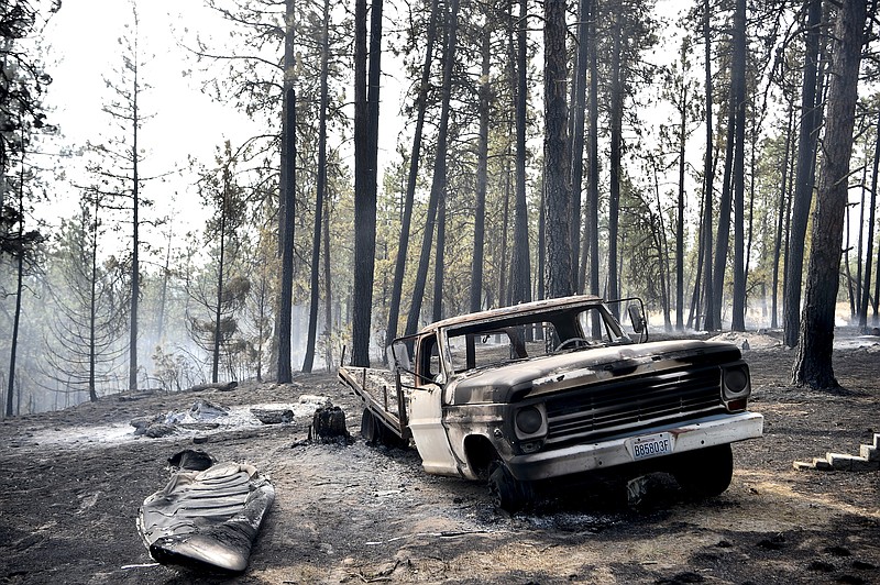 
              A charred truck is seen near the home of Julie Thayer and her husband, Art, on South Yale Road near Valleyford, Wash., on Monday, Aug 22, 2016. The Thayers had been hiking over the weekend and returned home Sunday night to find their home destroyed. (Tyler Tjomsland/The Spokesman-Review via AP)
            