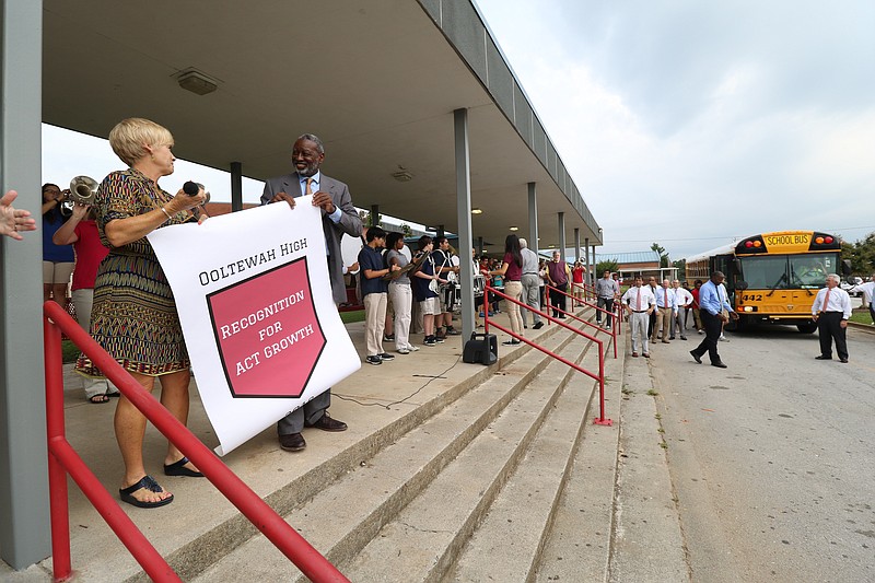 Principal Robin Copp receives a banner from Interim Superintendent Dr. Kirk Kelly at Ooltewah High School on Wednesday, Aug. 24, 2016, to celebrate ACT scores being up in Hamilton county. 