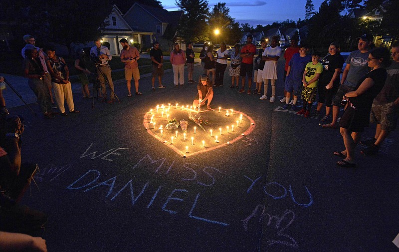 
              Friends and  family of Daniel Harris gather around a heart drawn onto Seven Oaks Drive during a candlelight vigil to remember Harris, a deaf motorist who was shot and killed by a state trooper, Monday, Aug. 22, 2016 in Charlotte, N.C. Harris, a deaf man who was shot and killed by a North Carolina state trooper after he didn’t stop for the officer’s blue lights was unarmed and likely did not understand the officer’s commands, the slain man’s family says.  (David T. Foster III/The Charlotte Observer via AP)
            