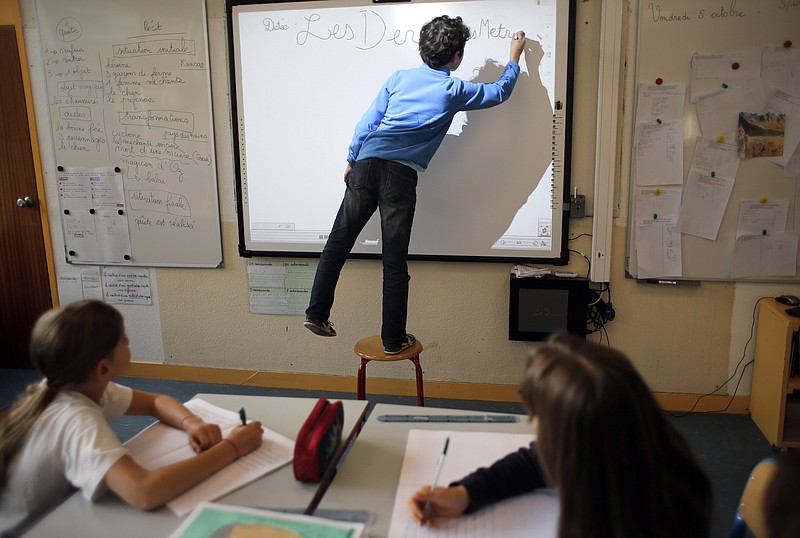 
              FILE - In this Oct. 5, 2012 file photo, a student writes on the board in La Ronce school, in Ville d'Avray, west of Paris. France's government has unveiled Wednesday Aug. 24, 2016 a plan to teach children how to react in case of an attack at school. Every school will have to organize three security drills per year, including one based on the scenario of an attack with at least one assailant inside the building. (AP Photo/Christophe Ena)
            