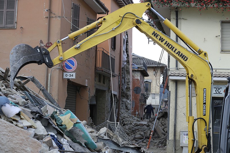 An excavator digs through rubble of collapsed buildings following an earthquake, in Amatrice, Italy, Wednesday, Aug. 24, 2016. The magnitude 6 quake struck at 3:36 a.m. and was felt across a broad swath of central Italy, including Rome where residents of the capital felt a long swaying followed by aftershocks.