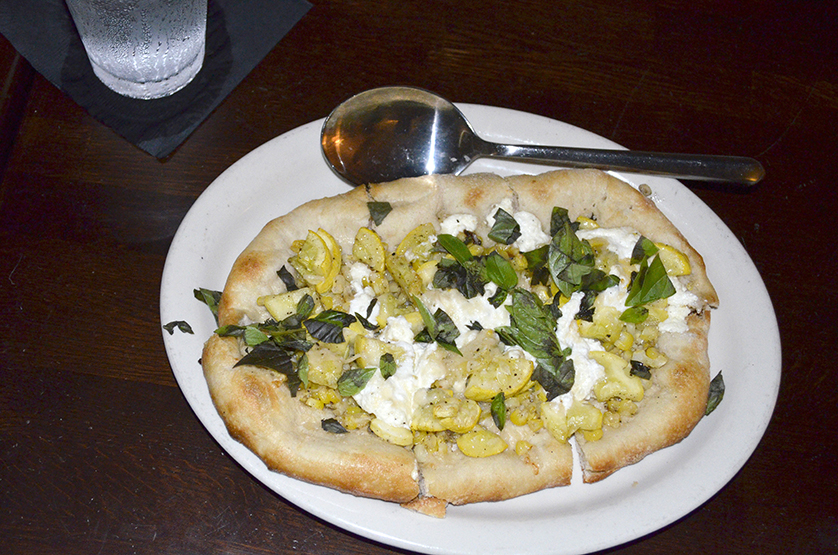 The primo course of flatbread pizza topped with corn, summer squash and ricotta.