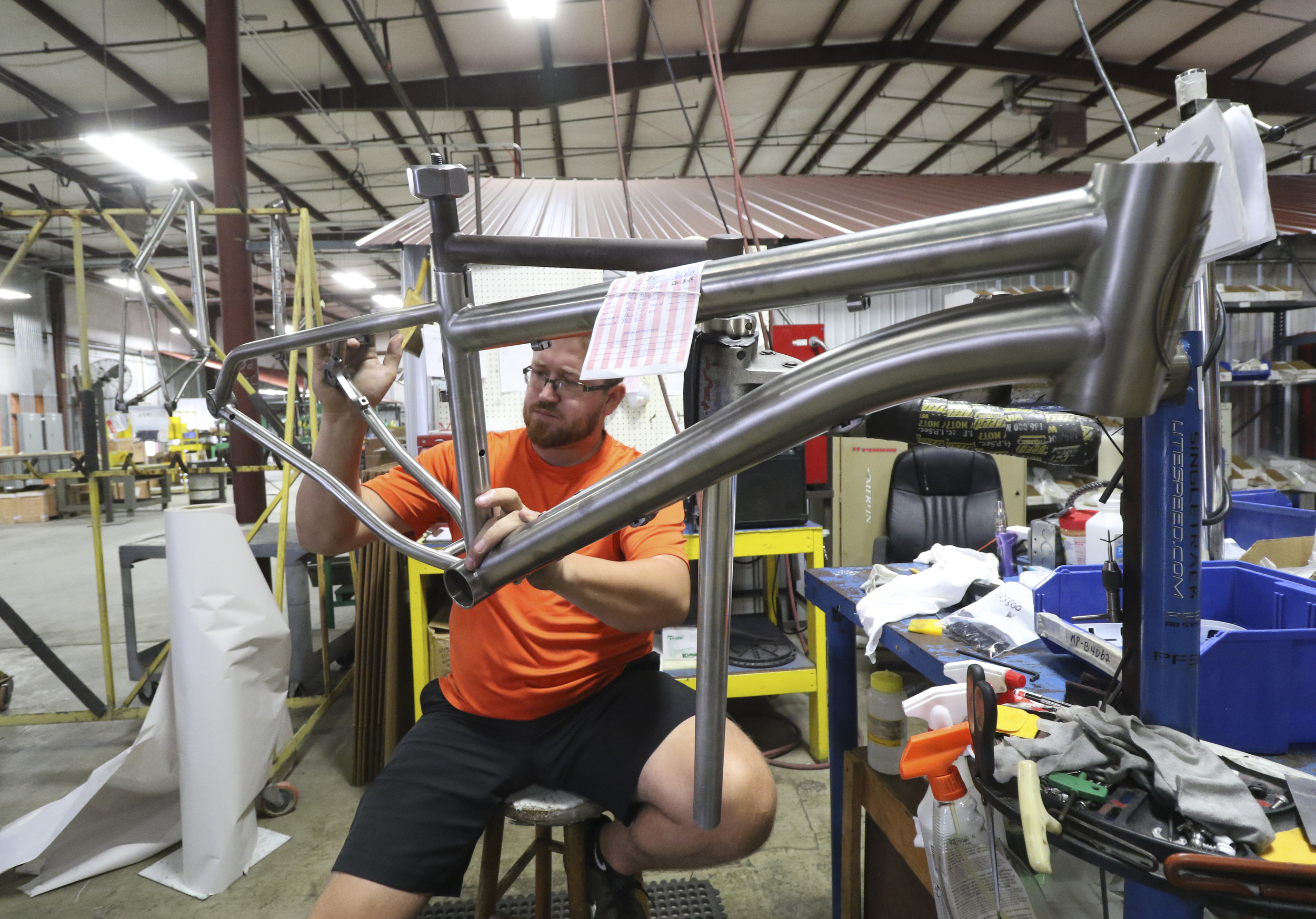 Staff Photo by Dan Henry / The Chattanooga Times Free Press- 8/18/16. Zack Pendergrass applies labels to a completed 2017 Kuiwa while at American Bicycle Group's new Amnicola Highway location on Thursday, August 18, 2016.