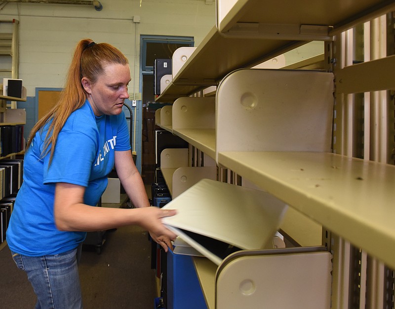 Elder's Ace Hardware employee Rachel Cain shelves binders during the 2015 United Way Day of Caring at the teachers supply depot on Roanoke Avenue.