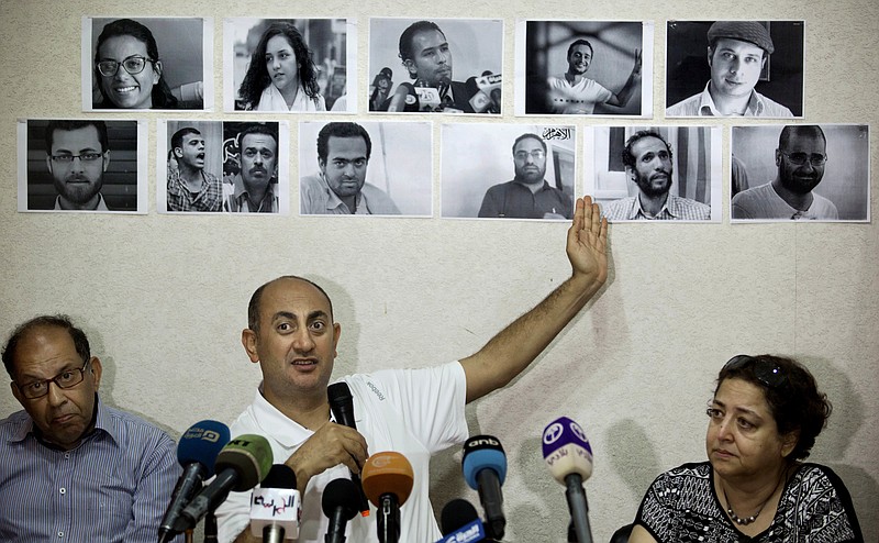 
              FILE - In this Wednesday, June 22, 2016 file photo, Egyptian lawyer and former presidential candidate Khaled Ali points to photos of jailed activists, who were arrested during protests over two disputed Red Sea islands, including Egyptian rights lawyer Malek Adly, top row third right, during a press conference, in Cairo, Egypt. An Egyptian court has ordered on Thursday, Aug. 25, 2016 the release of the prominent rights lawyer held in solitary confinement for the past three months after he challenged in court a decision by the country's president to hand over two Red Sea islands to Saudi Arabia. (AP Photo/Amr Nabil, File)
            
