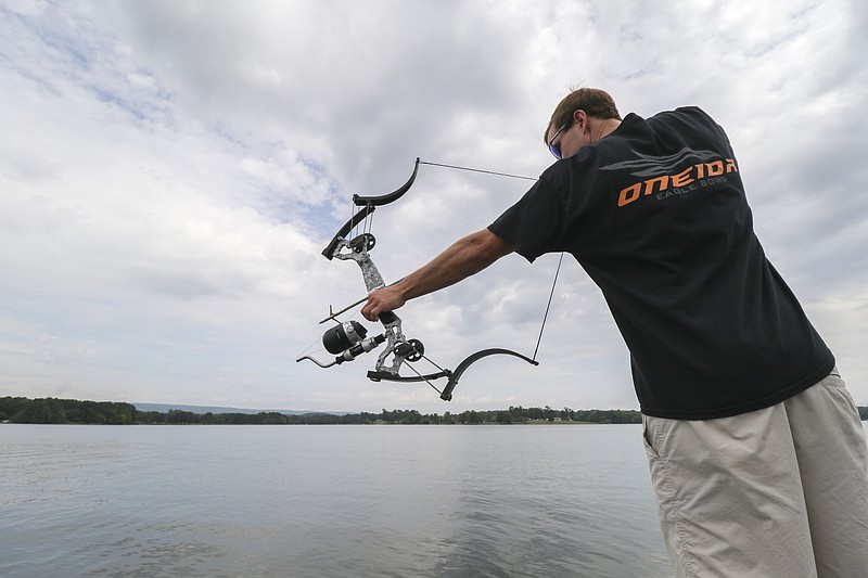 Bradley Britt, a Chattanooga fireman, shoots at a gar while out on Chickamauga Lake with his father Richard Britt. Gar are common game for bowfishermen, who also shoot for carp and catfish.