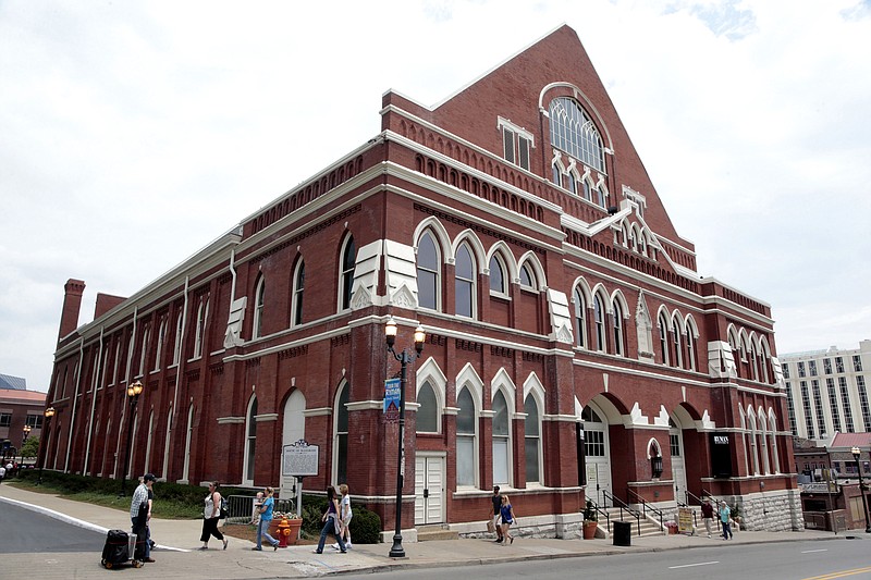 Pedestrians pass the Ryman Auditorium, Monday, June 8, 2015, in Nashville, Tenn. The Tennessean reports that the Ryman is ready for its grand reopening after a yearlong, $14 million expansion. (AP Photo/Mark Humphrey)