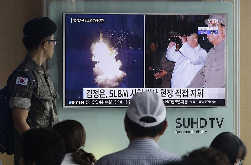 
              FILE - In this Thursday, Aug. 25, 2016, file photo, a South Korean army soldier watches a TV news program showing images published in North Korea's Rodong Sinmun newspaper of North Korea's ballistic missile believed to have been launched from underwater and North Korean leader Kim Jong-un, at Seoul Railway station in Seoul, South Korea. The UN Security Council is strongly condemning four North Korean ballistic missile launches in July and August, calling them "grave violations" of a ban on all ballistic missile activity. A press statement approved by all 15 members Friday night deplored the fact that the North's ballistic missile activities are contributing to its development of nuclear weapon delivery systems and increasing tensions. (AP Photo/Ahn Young-joon, File)
            