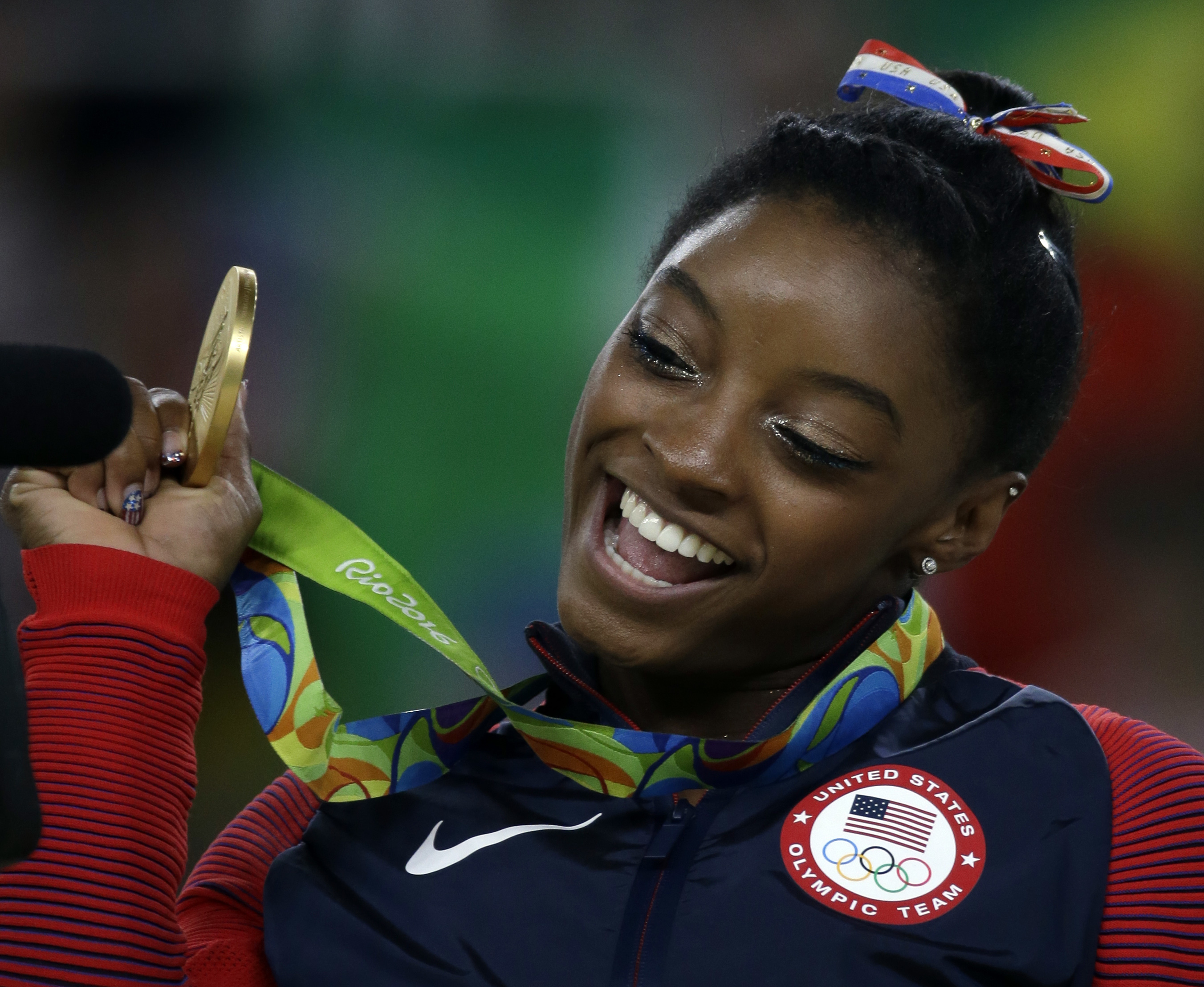 United States' Simone Biles displays her gold medal for floor during the artistic gymnastics women's apparatus final at the 2016 Summer Olympics in Rio de Janeiro, Brazil, Tuesday, Aug. 16, 2016. (AP Photo/Rebecca Blackwell)