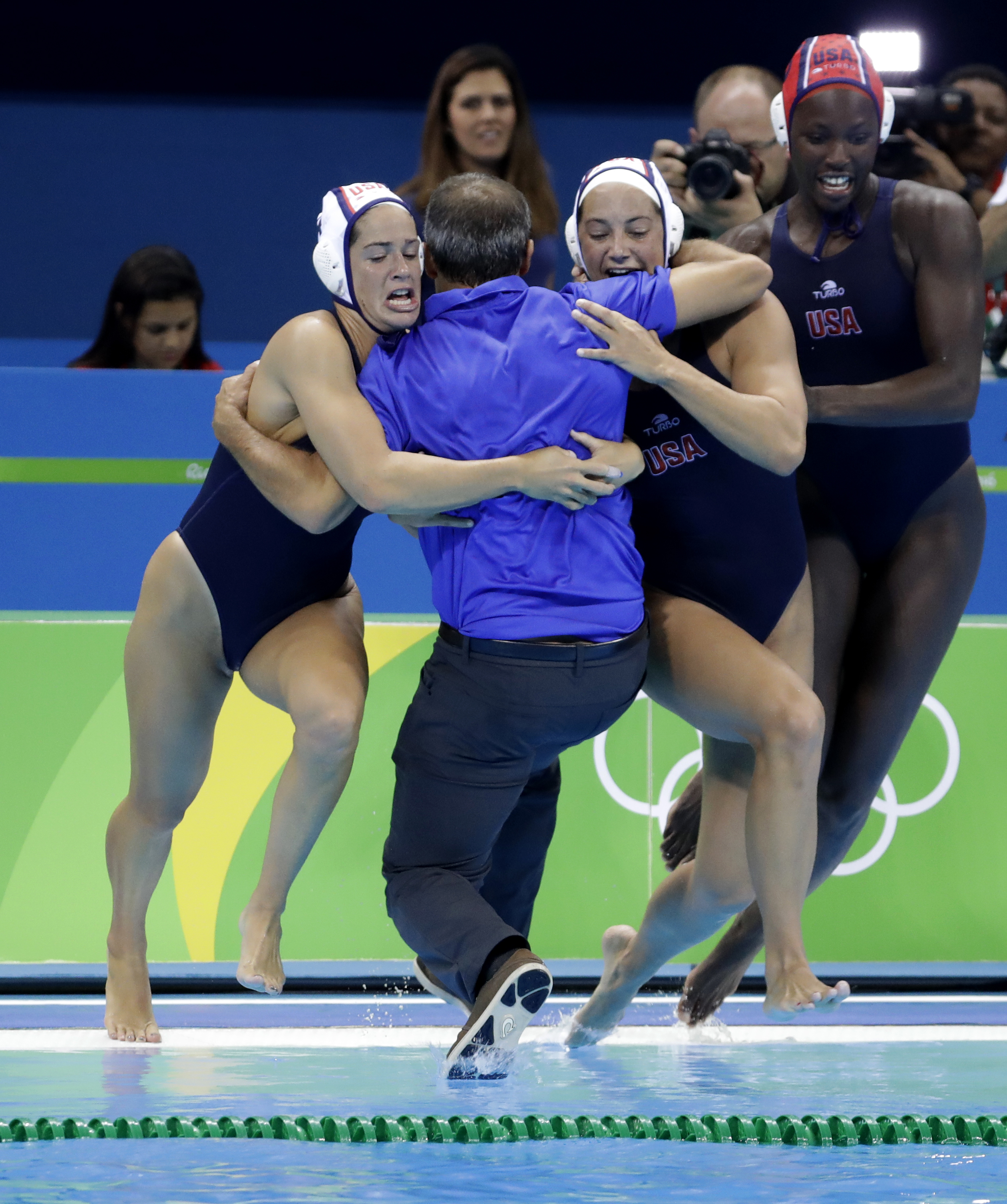 Members of the United States team jump into water as they celebrate their victory during women's gold medal water polo match against Italy at the 2016 Summer Olympics in Rio de Janeiro, Brazil, Friday, Aug. 19, 2016. (AP Photo/Eduardo Verdugo)