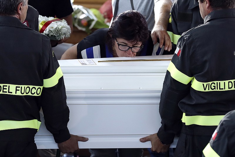
              A woman kisses the coffin of 9-year-old Giulia Rinaldo, as it is carried outside the gymnasium at the end of the state funeral service in Ascoli Piceno, Italy, Saturday, Aug. 27, 2016. Funerals for some victims took place on Friday, while those for many others are expected in the coming days.(AP Photo/Andrew Medichini)
            