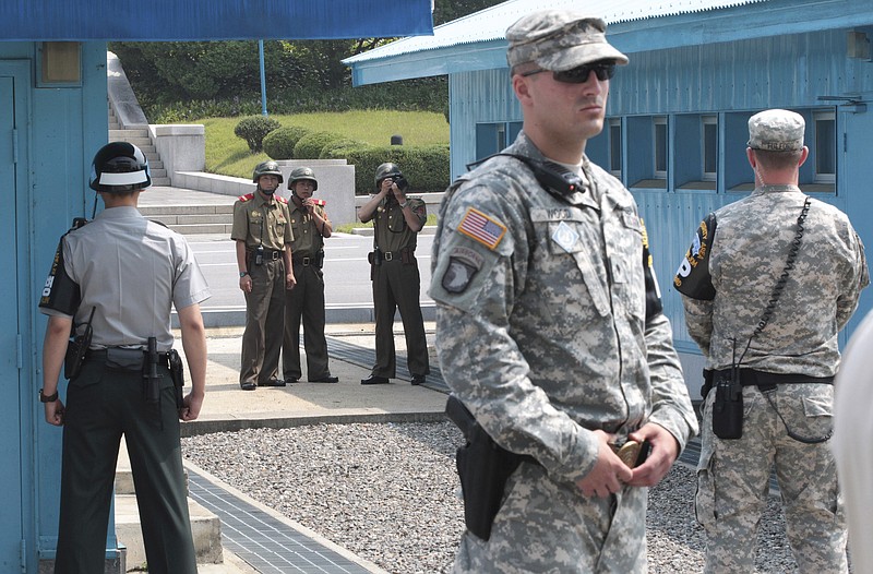 
              FILE - In this July 27, 2014 file photo, North Korean army soldiers watch the south side while a South Korean and United States Army soldiers stand guard at the border villages of Panmunjom in Paju, South Korea. North Korea has threatened on Saturday, Aug. 27, 2016, to aim fire at the lighting equipment used by American and South Korean troops at a truce village inside the Demilitarized Zone that divides the two Korea. (AP Photo/Ahn Young-joon, File)
            