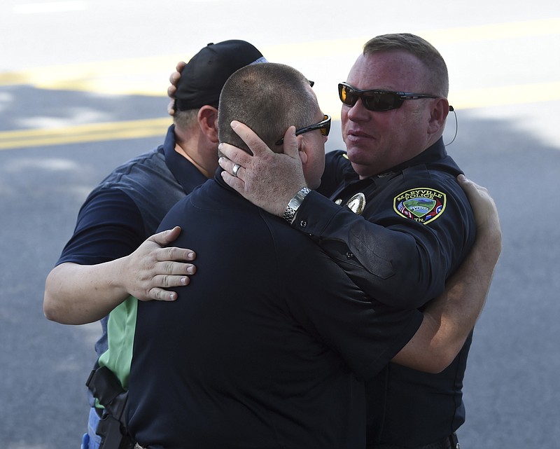
              Maryville Police Department Detective John Foley, right, hugs Blount County Sheriff's Office investigators Andy Waters, center, and Joey Parton after the body of slain police officer Kenny Moats passed in a procession Friday, Aug. 26, 2016, in Maryville, Tenn. The nine-year veteran officer was killed Thursday after he was shot while answering a domestic violence call. Brian Keith Stalans, 44, was taken into custody after the shooting and is being held for investigation pending charges that will likely be placed Friday, according to the Blount County Sheriff's Office. (Amy Smotherman Burgess/Knoxville News Sentinel via AP)
            