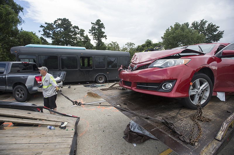 
              Tow truck operator Lee Maguire helps clean up the scene of a fatal wreck on Interstate 10 near Laplace on Sunday, Aug. 28, 2016. A bus full of construction workers, seen, hit a firetruck on an elevated highway Sunday, killing a few people and injuring dozens, several of them seriously, Louisiana State Police said. (Chris Granger/NOLA.com The Times-Picayune via AP)
            