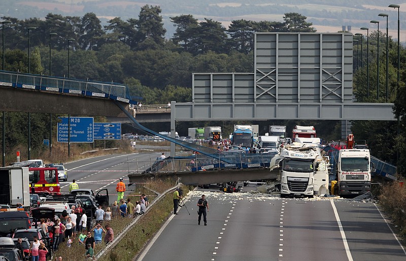 
              The scene on the London-bound M20 motorway, about 30 miles (48 kilometers) southeast of the capital, after a lorry hit a pedestrian bridge, causing it to collapse, Saturday Aug. 27, 2016. Witnesses and emergency services say a truck has struck an overpass and collapsed a pedestrian bridge onto one of England’s busiest motorways, the M20, injuring one person. (Steve Parsons/PA via AP)
            