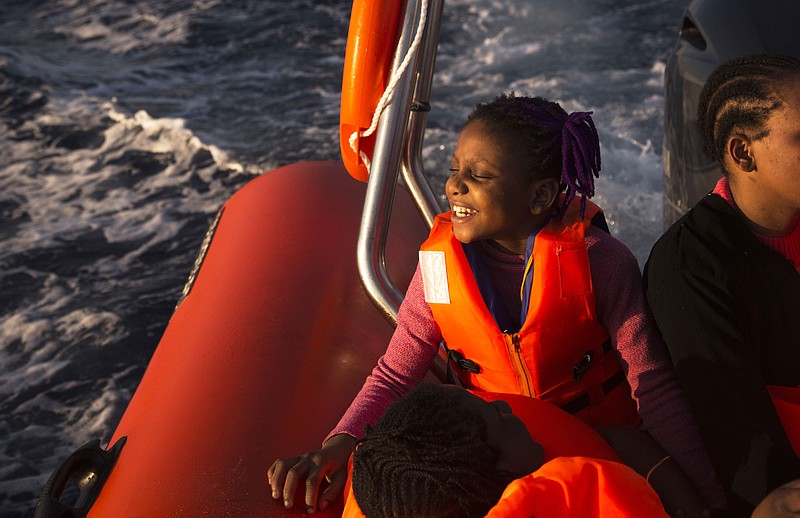 
              Sira, 9, a migrant from Nigeria, smiles as she rides aboard a boat of the Proactiva Open Arms NGO, after being rescued during an operation in the Mediterranean sea, about 17 miles north of Sabratah, Libya, Saturday, Aug. 20, 2016. (AP Photo/Emilio Morenatti)
            